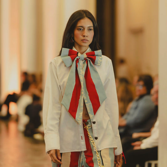 Corbatín Ritual 2:00 PM XL a rayas rojo y celeste sobre camisa blanca, en pasarela – Ale Ardila Studios
