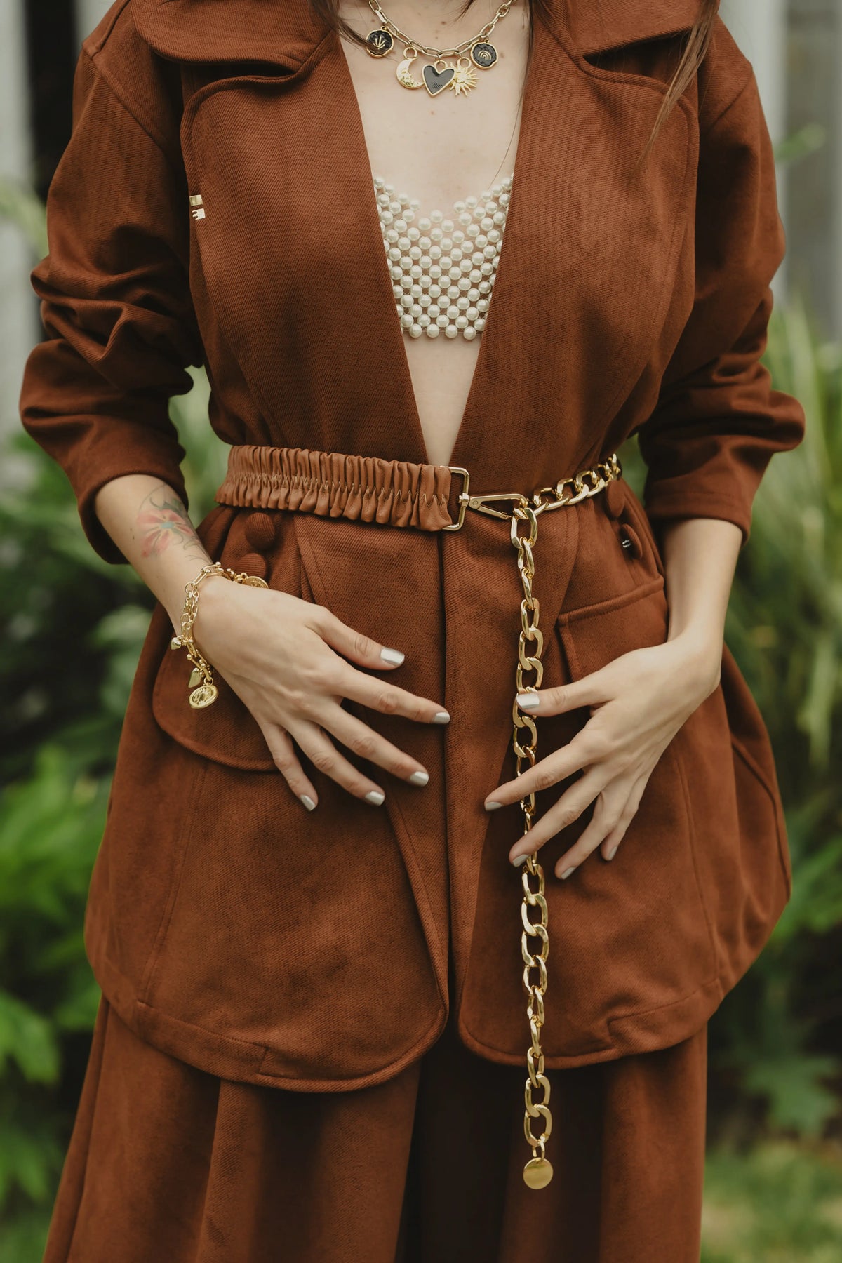 Detalle de la cintura del Sobretodo Tintico Mocca con cinturón de cadena dorada – Ale Ardila Studios
