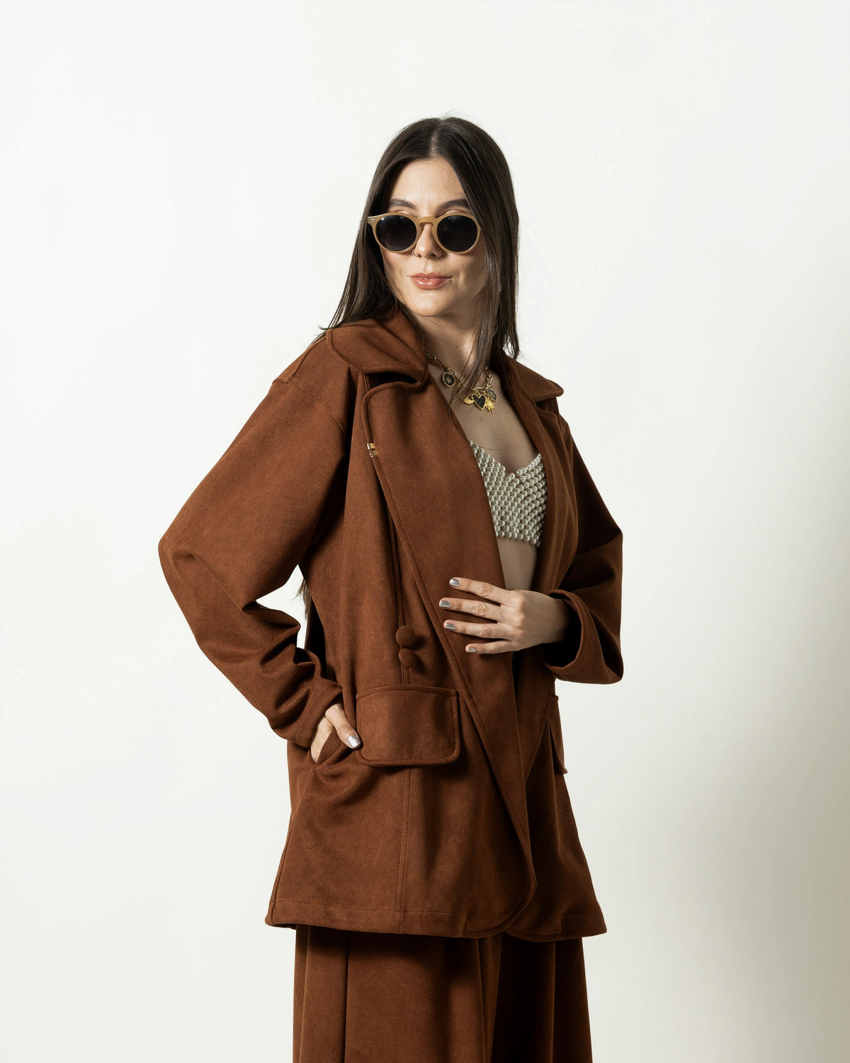 Sobretodo Tintico Mocca oversize, vista frontal con manos en la cintura – Ale Ardila Studios