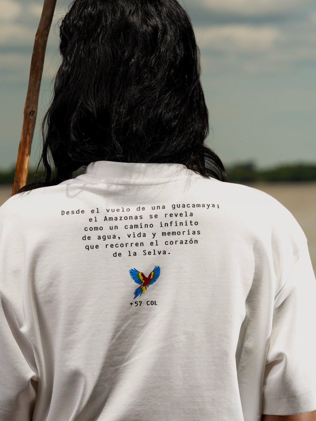 Vista de espalda de la Camiseta Amazonas con el mensaje de la colección y una guacamaya – Ale Ardila Studios